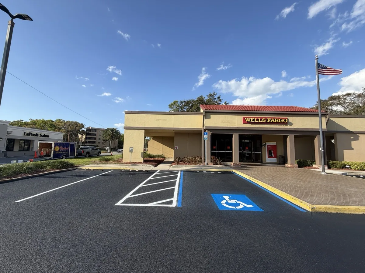 Freshly sealcoated and striped Wells Fargo parking lot in Clearwater with ADA handicap spaces by Radiant Striping